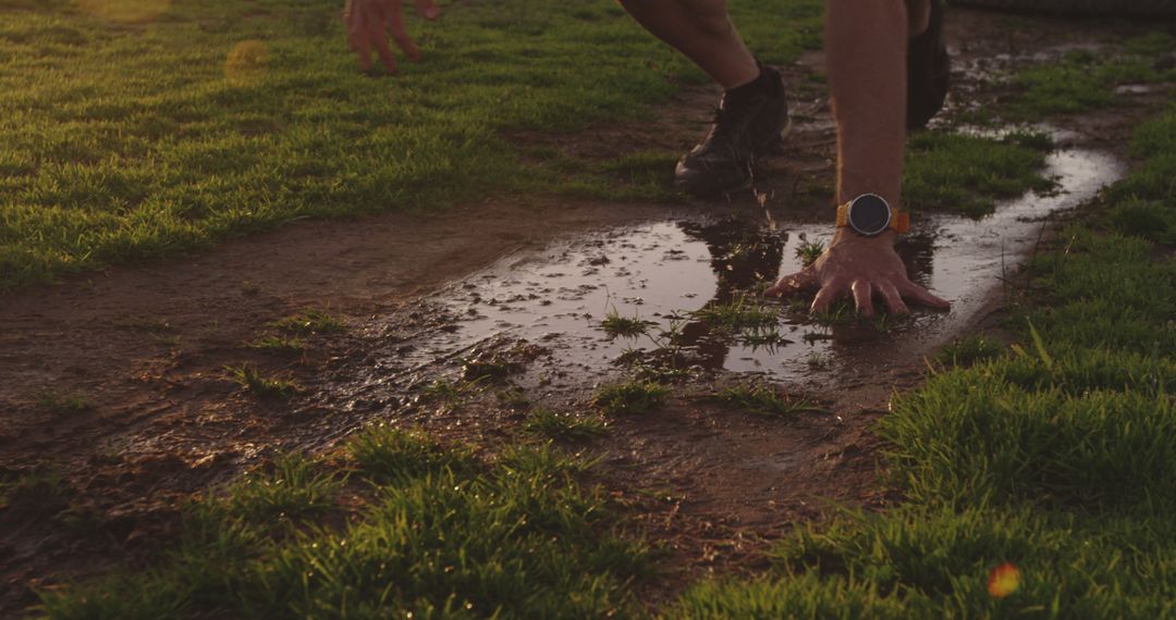 Athlete Preparing for Sprint Start in Wet Muddy Field at Sunset - Free Images, Stock Photos and Pictures on Pikwizard.com