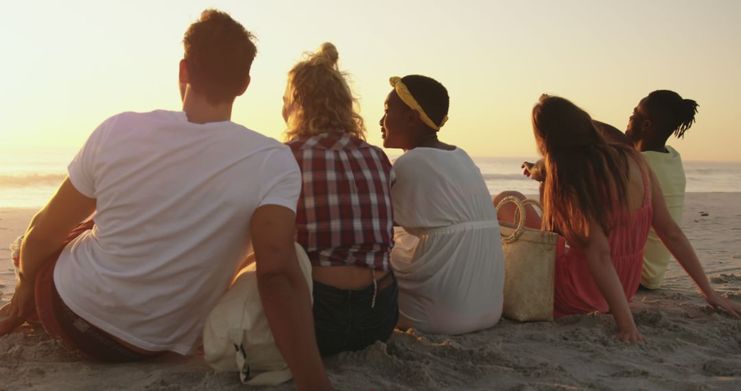 Diverse Group of Young Friends Relaxing on Beach at Sunset - Free Images, Stock Photos and Pictures on Pikwizard.com