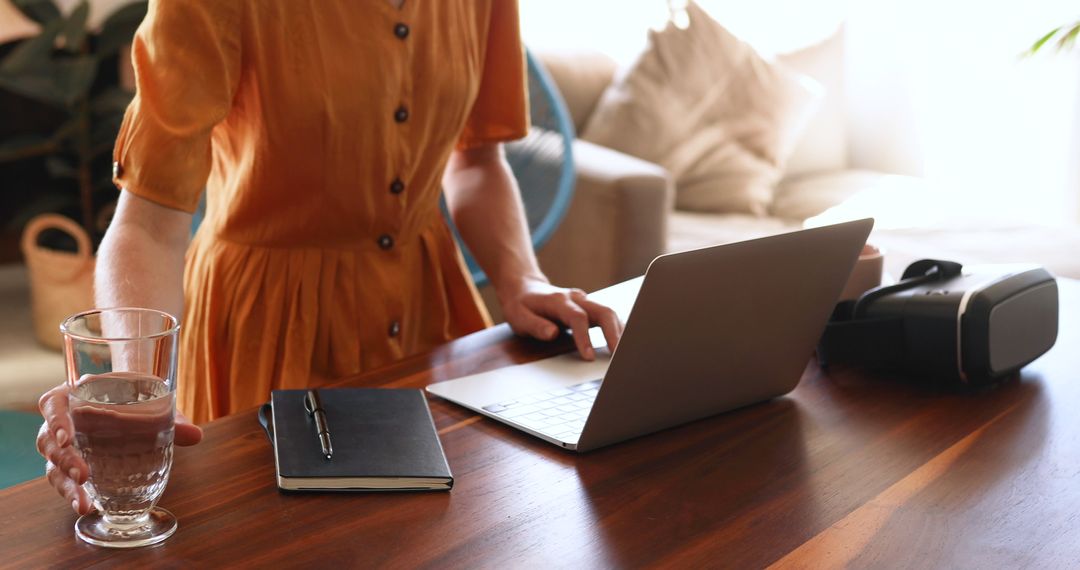 Woman Working from Home with Laptop and VR Headset on Wooden Table - Free Images, Stock Photos and Pictures on Pikwizard.com