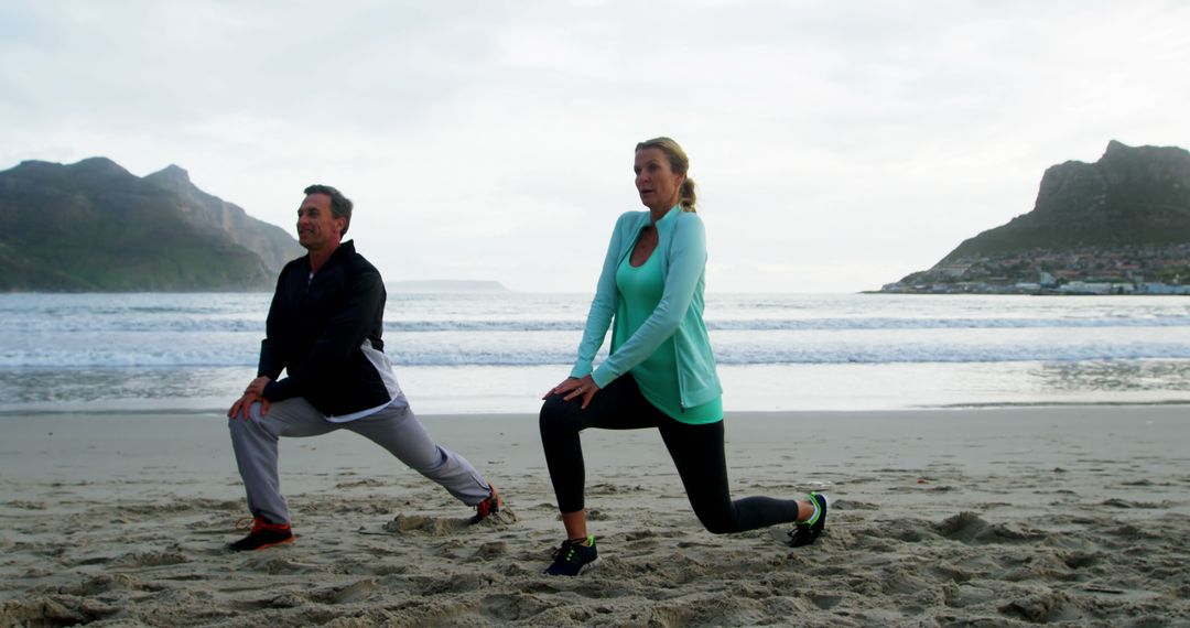 Couple Exercising on Beach with Scenic Mountain View - Free Images, Stock Photos and Pictures on Pikwizard.com