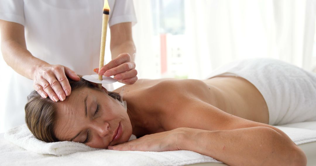 Woman receiving ear candling treatment at spa - Free Images, Stock Photos and Pictures on Pikwizard.com