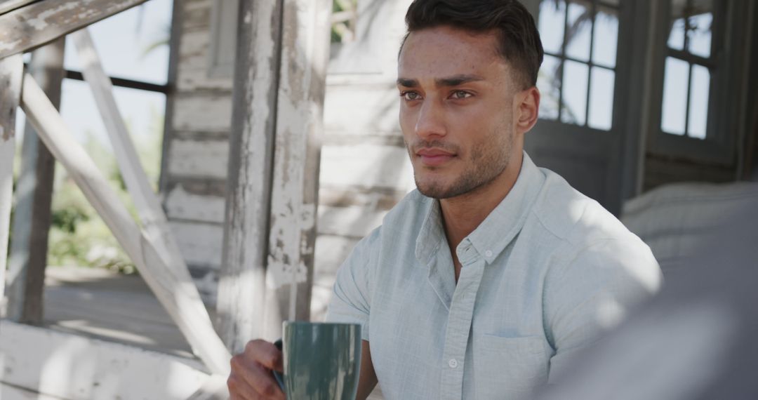 Man Relaxing Outdoors with Coffee on Rustic Porch - Free Images, Stock Photos and Pictures on Pikwizard.com