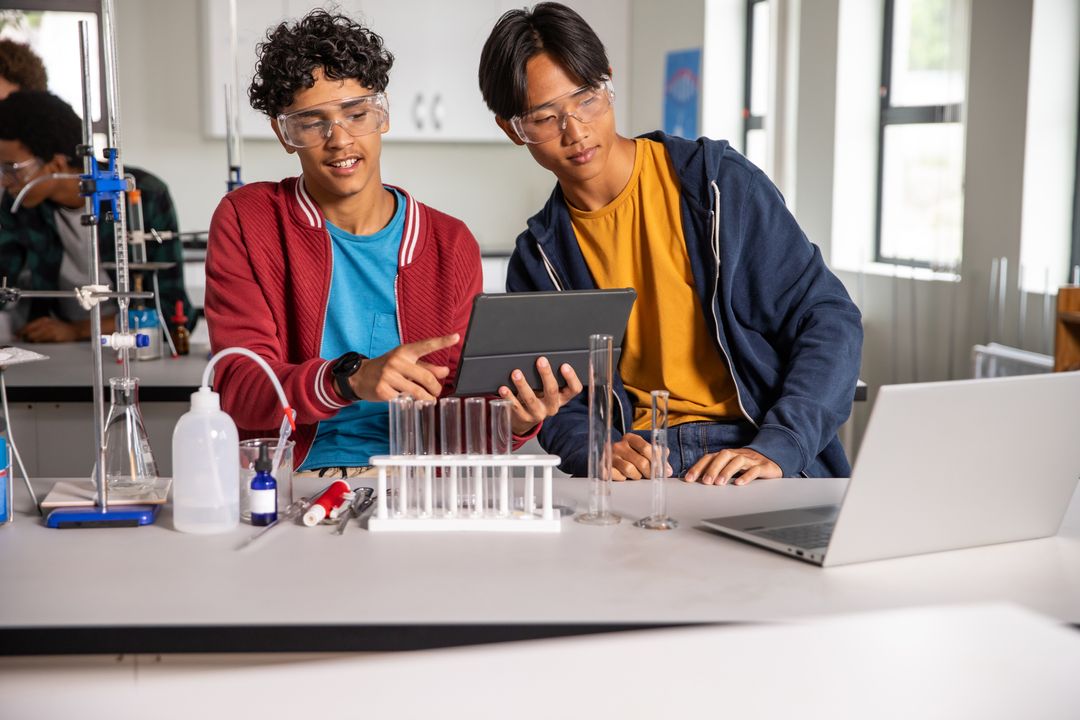 Teen Students Collaborating in Science Lab Using Tablet and Laboratory Equipment