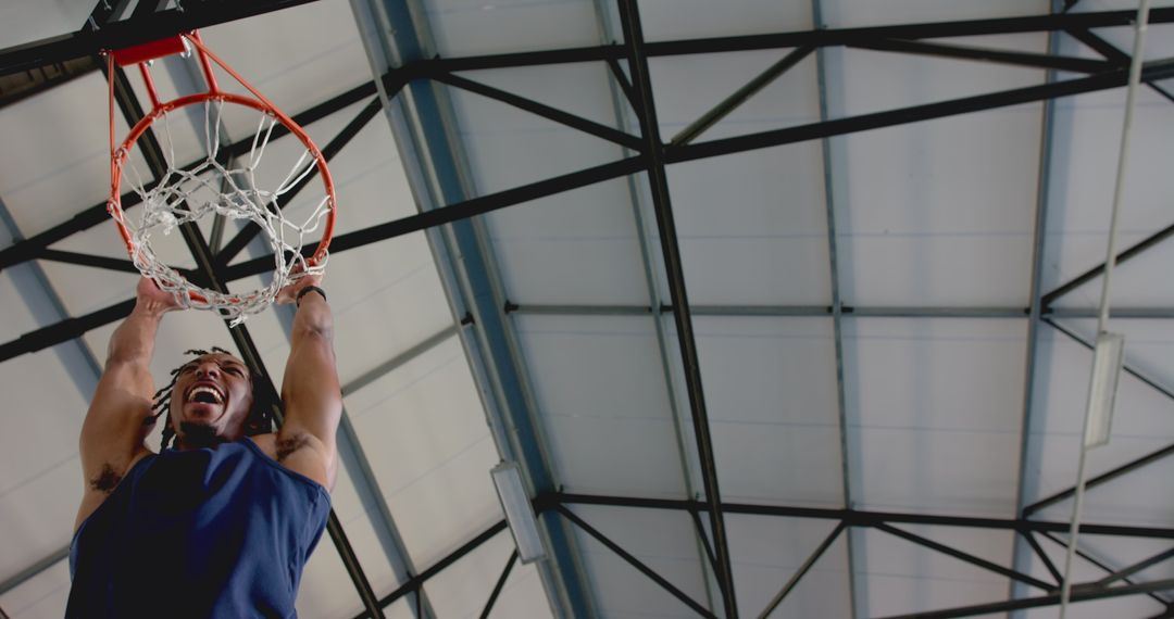 Energetic Basketball Player Dunking at Indoor Court