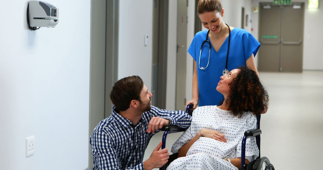 Nurse assisting pregnant woman in wheelchair with supportive partner - Free Images, Stock Photos and Pictures on Pikwizard.com