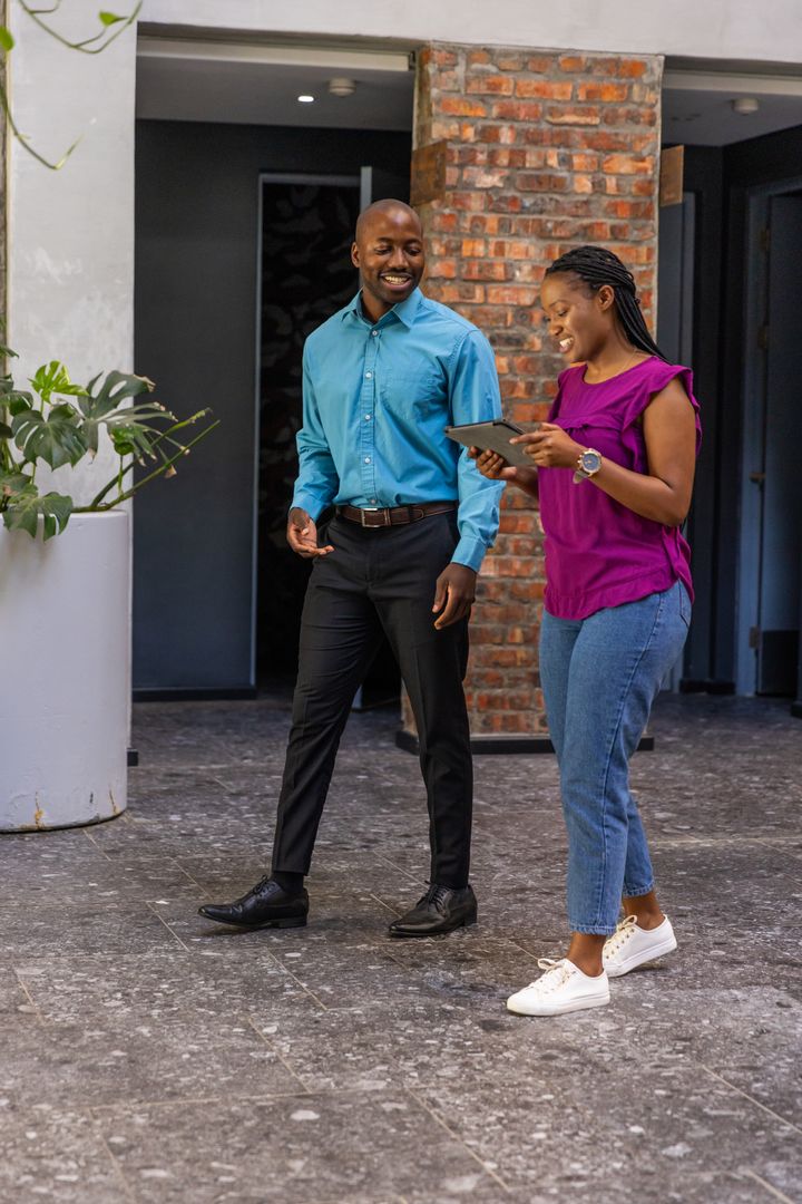 Professional Colleagues Discussing Project Using Tablet Technology