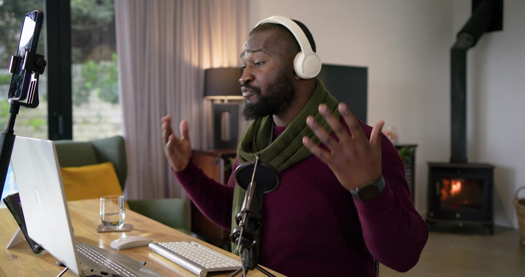 African American podcaster streaming from cozy home studio with laptop and microphone