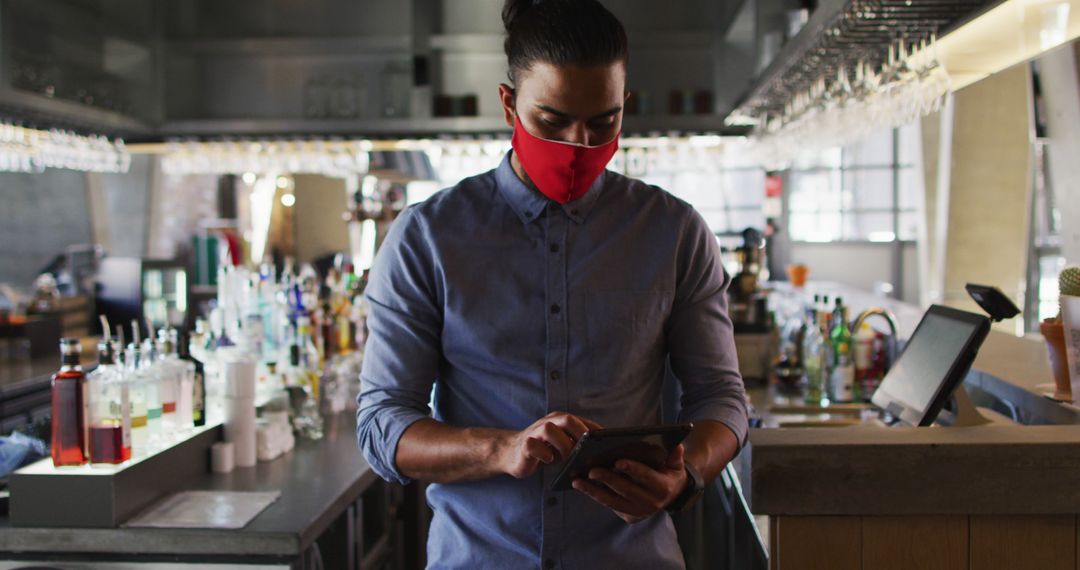 Cafe Owner in Mask Using Tablet in Stylish Urban Setting