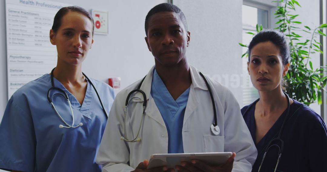 Diverse Medical Team Standing in Hospital Lobby with Determined Expressions - Free Images, Stock Photos and Pictures on Pikwizard.com