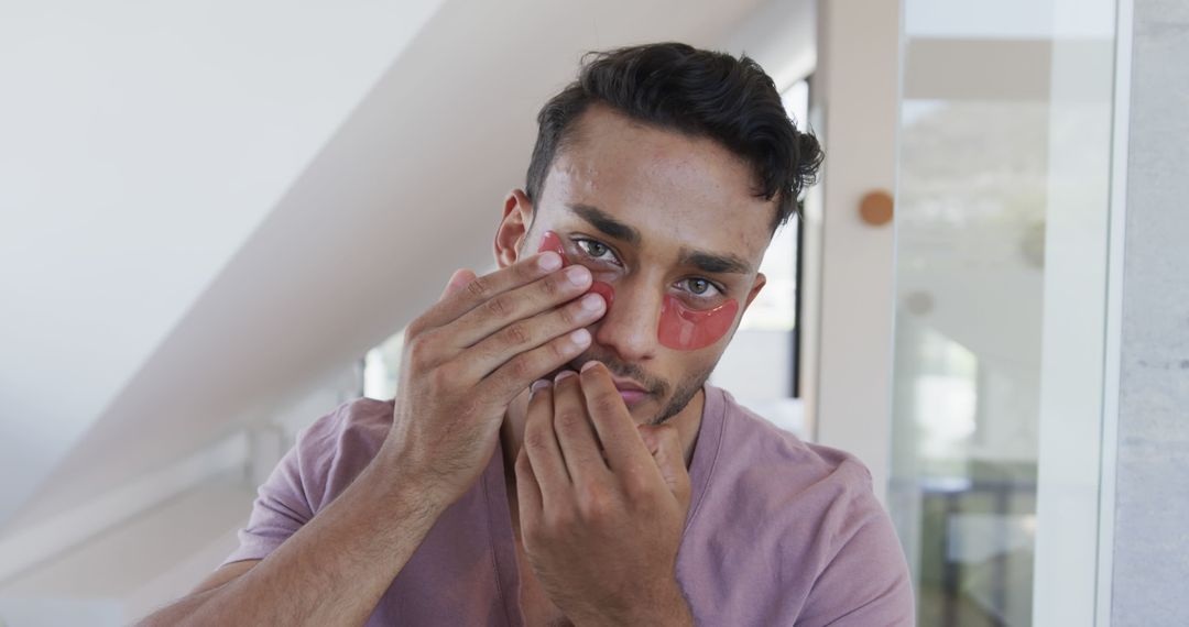 Young Man Applying Under Eye Patches for Skincare - Free Images, Stock Photos and Pictures on Pikwizard.com