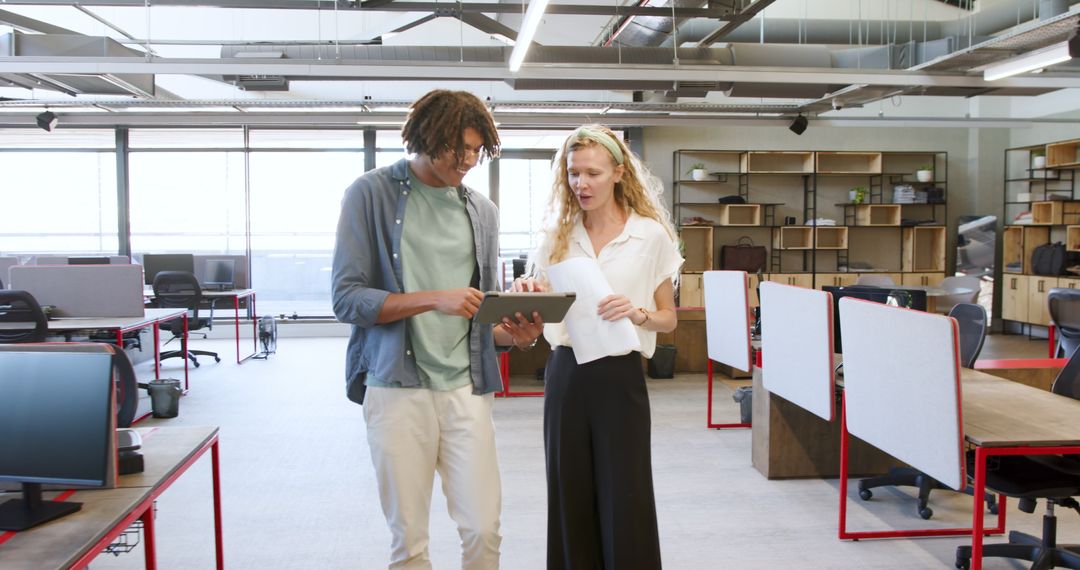Colleagues Collaborating in Modern Office Space with Tablet
