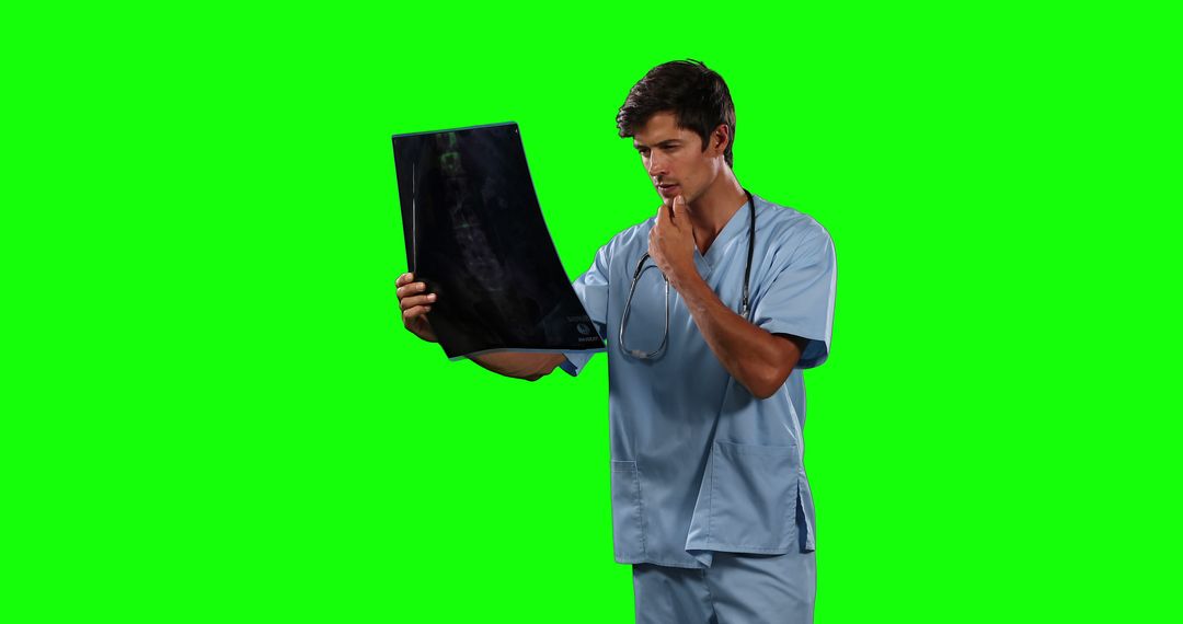 Male Doctor Analyzing X-ray Against Green Background - Free Images, Stock Photos and Pictures on Pikwizard.com