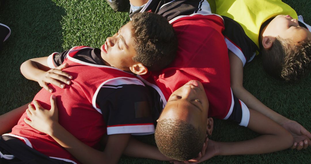 Soccer Kids Lying on Green Field in Bright Sunlight - Free Images, Stock Photos and Pictures on Pikwizard.com