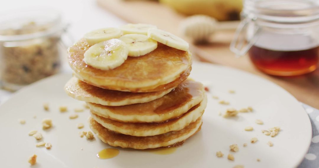 Stack of Fluffy Pancakes with Sliced Bananas and Maple Syrup