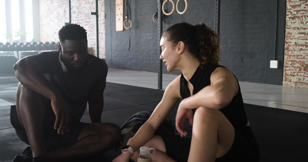 Diverse Fitness Enthusiasts Relaxing in Modern Gym