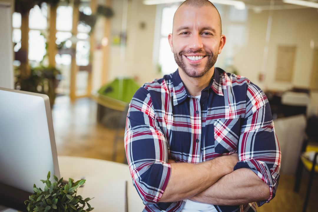 Smiling Businessman with Arms Crossed in Modern Office