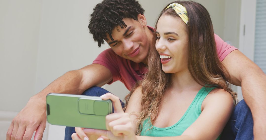 Smiling Couple Taking Selfie Indoors Using Smartphone