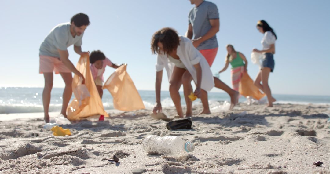 Diverse Group Engaged in Beach Cleanup Collecting Trash