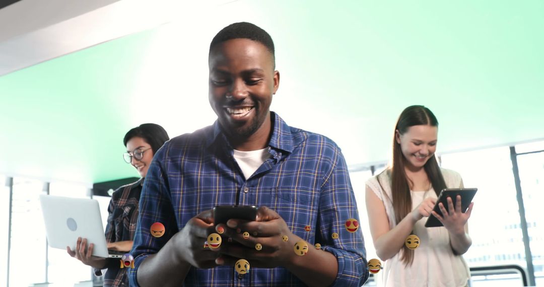 Diverse Team Collaborating with Digital Devices and Emojis Swirling