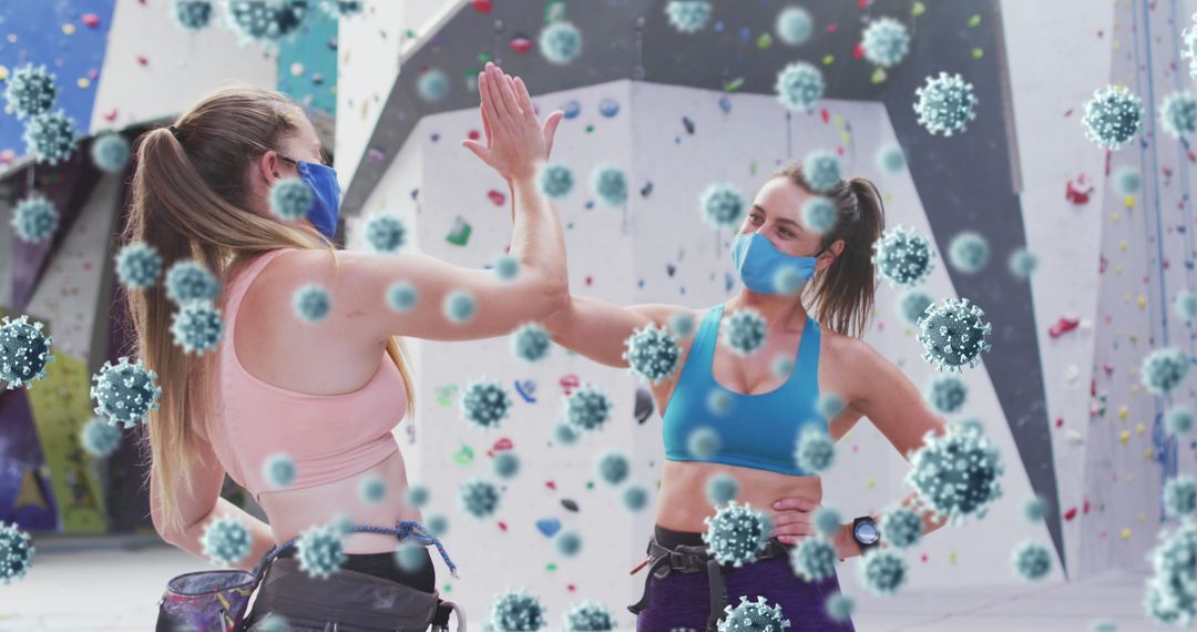 Masked Rock Climbers High-Fiving Amongst Virus Models at Climbing Gym