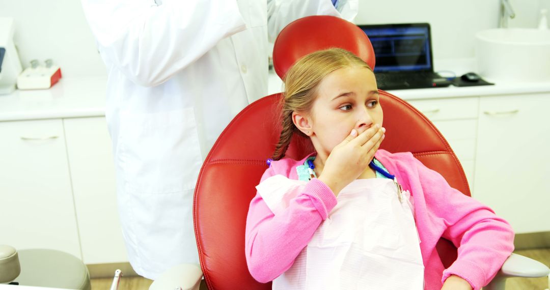 A young girl exhibits dental anxiety in a clinical setting, hinting at a common childhood fear. - Free Images, Stock Photos and Pictures on Pikwizard.com