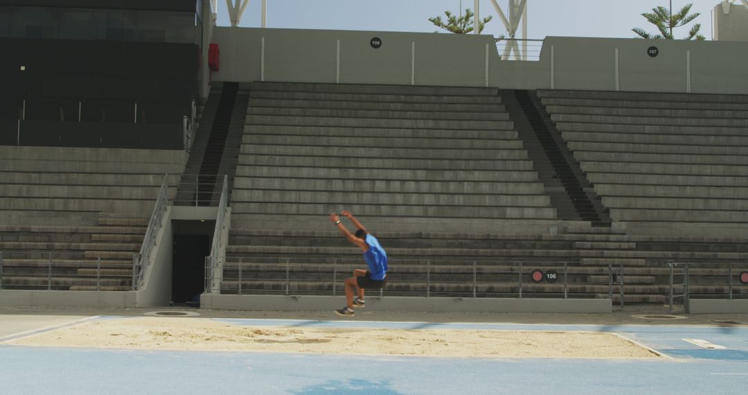 Male Athlete in Mid-air Long Jump at Empty Stadium - Free Images, Stock Photos and Pictures on Pikwizard.com