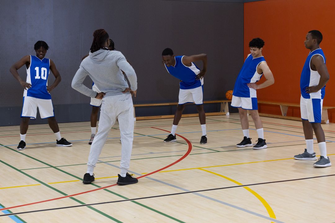 Basketball Team Warming Up with Coach in Gym