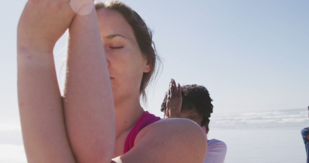 Women Practicing Yoga on Beach with Focused Expressions - Free Images, Stock Photos and Pictures on Pikwizard.com