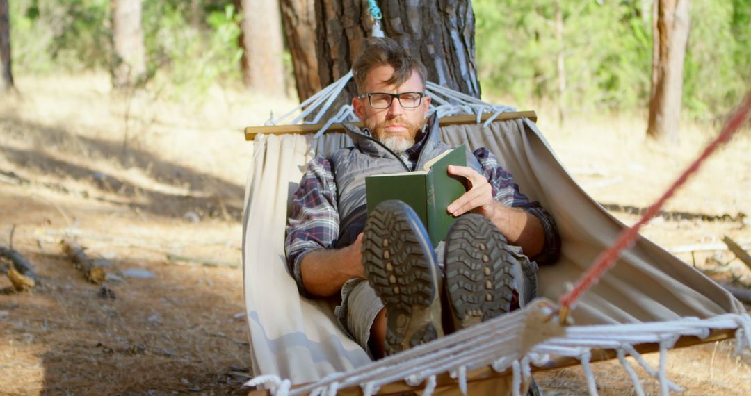 Man Relaxing in Hammock Reading Book in Forest - Free Images, Stock Photos and Pictures on Pikwizard.com