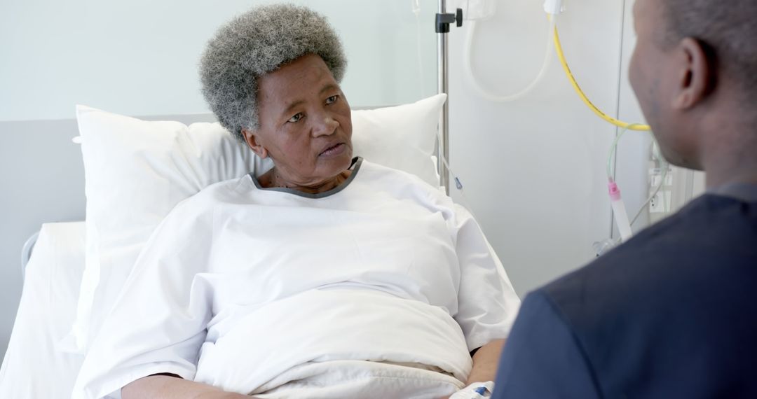 African American Elderly Patient Speaking with Male Nurse in Hospital Bed - Free Images, Stock Photos and Pictures on Pikwizard.com