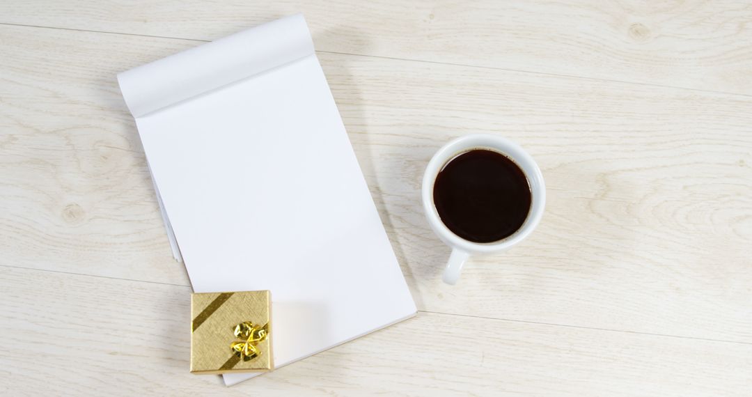 Blank Notepad with Coffee and Gift Box on Light Wood Desk - Free Images, Stock Photos and Pictures on Pikwizard.com