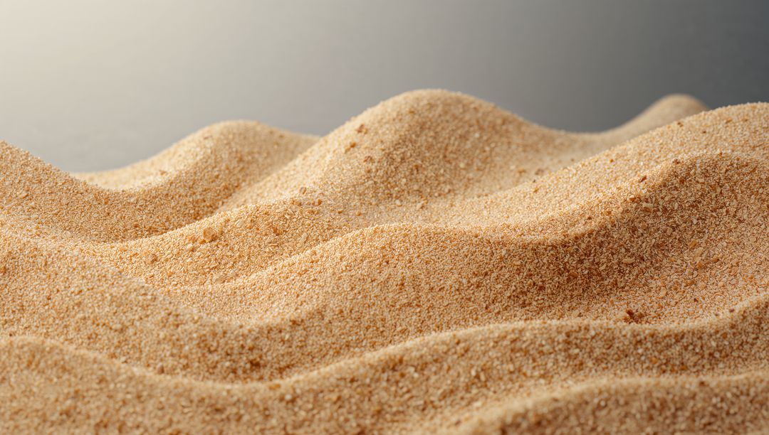 Macro sand dune ridges creating soft wave texture in warm beige granular close-up