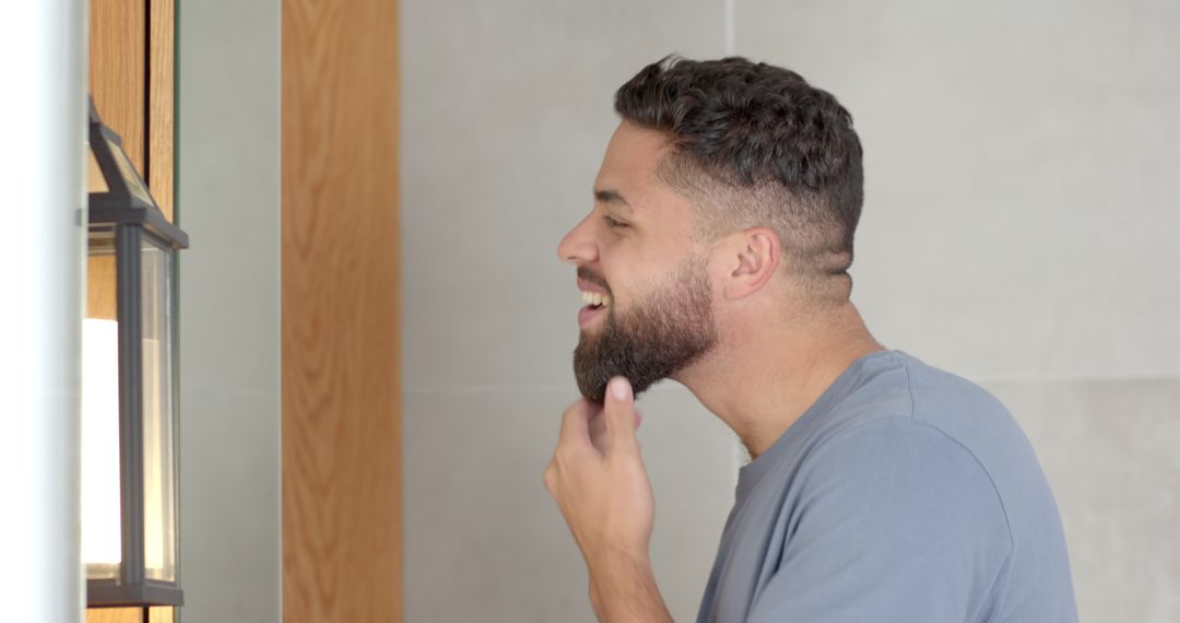 Man Grooming Beard in Modern Bathroom with Warm Lighting