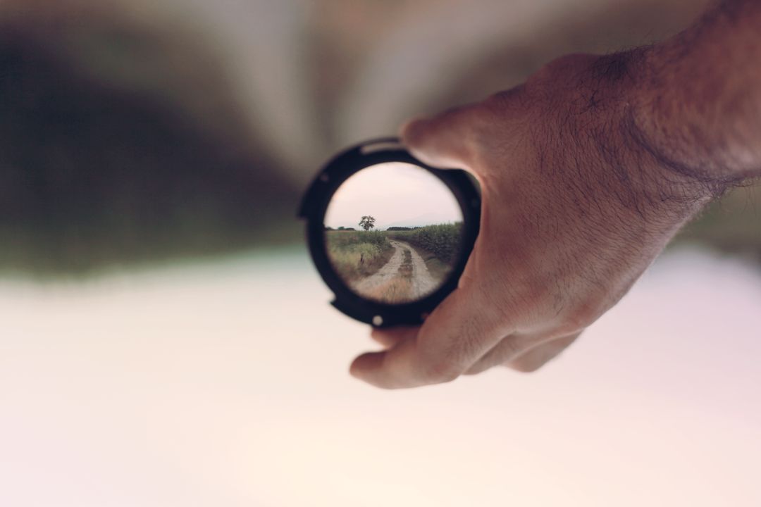 Hand Holding Lens with Blurred Scenic Path in Background - Free Images, Stock Photos and Pictures on Pikwizard.com