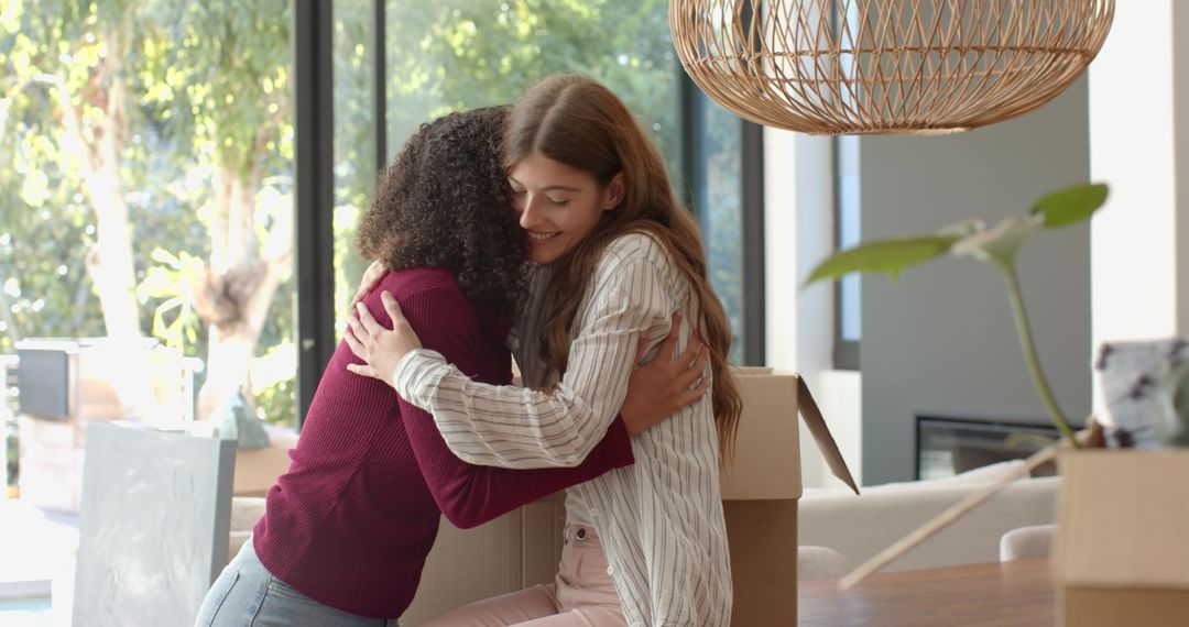 Diverse Friends Embracing While Unpacking in New Home