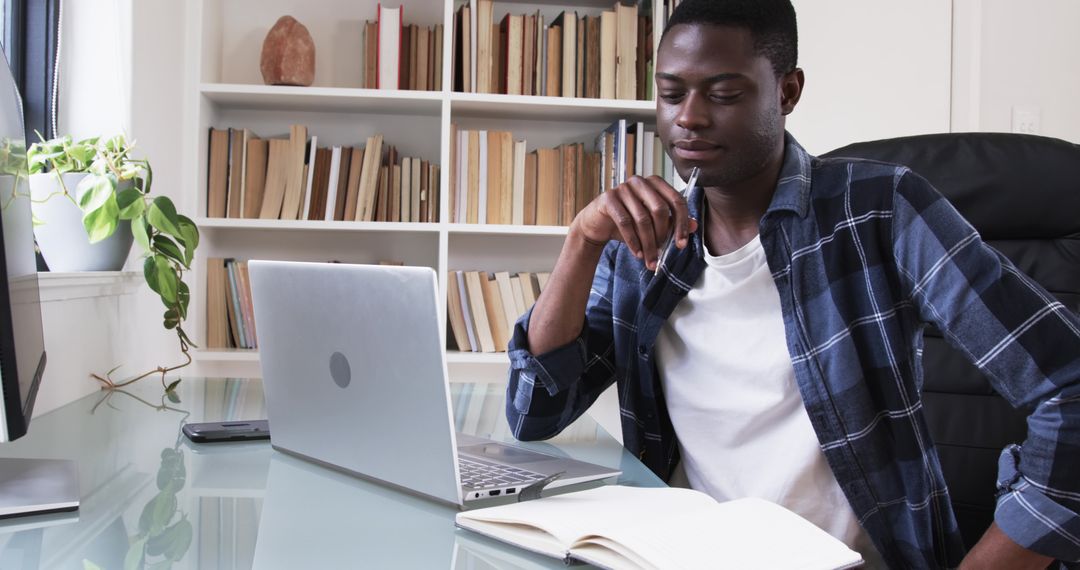 Focused Man Studying with Laptop in Modern Workspace