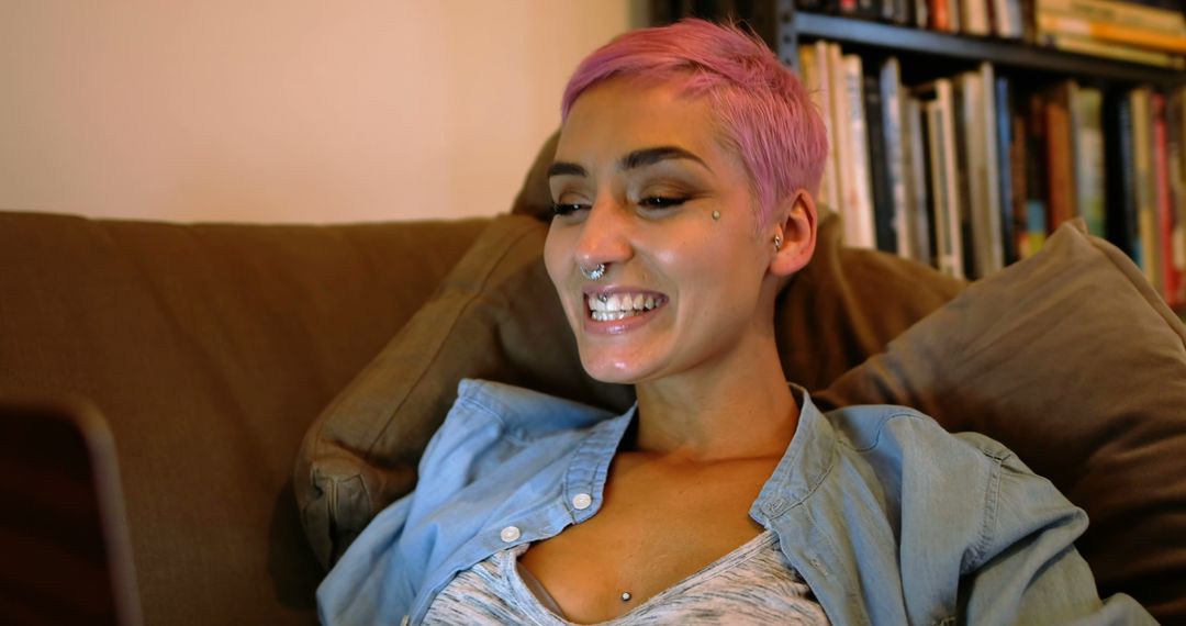 Woman With Pink Hair and Piercings Smiling While Using Laptop - Free Images, Stock Photos and Pictures on Pikwizard.com