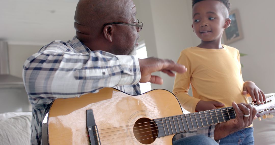 Grandfather Teaching Grandson How to Play Acoustic Guitar at Home - Free Images, Stock Photos and Pictures on Pikwizard.com