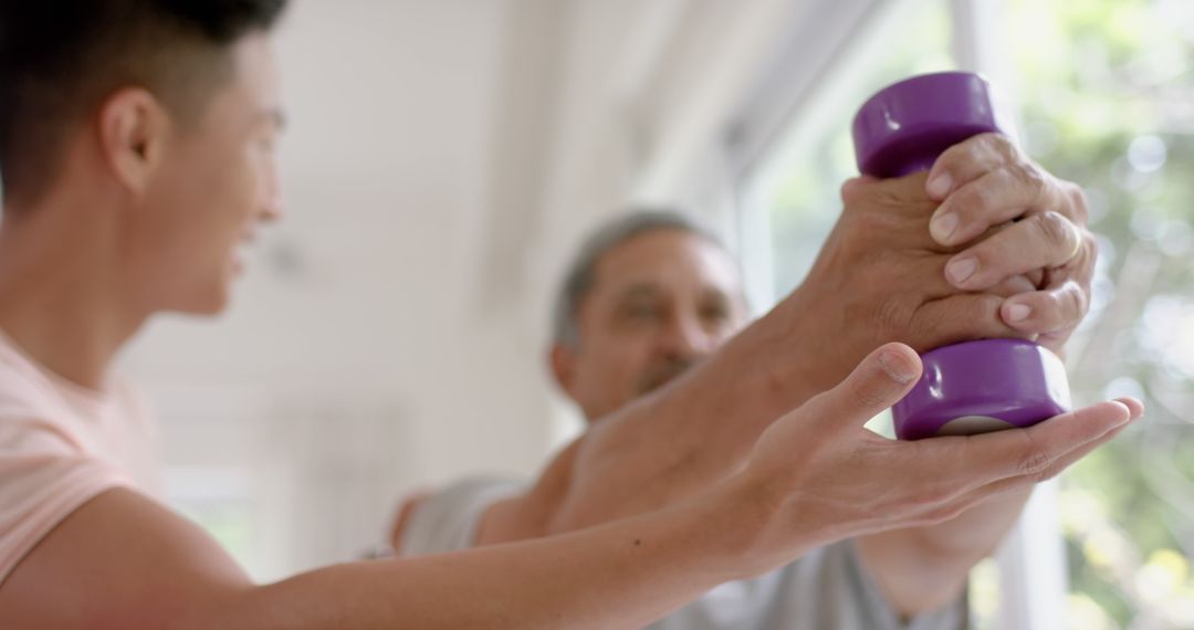 Young Man Helping Senior During Arm Exercising with Dumbbells - Free Images, Stock Photos and Pictures on Pikwizard.com