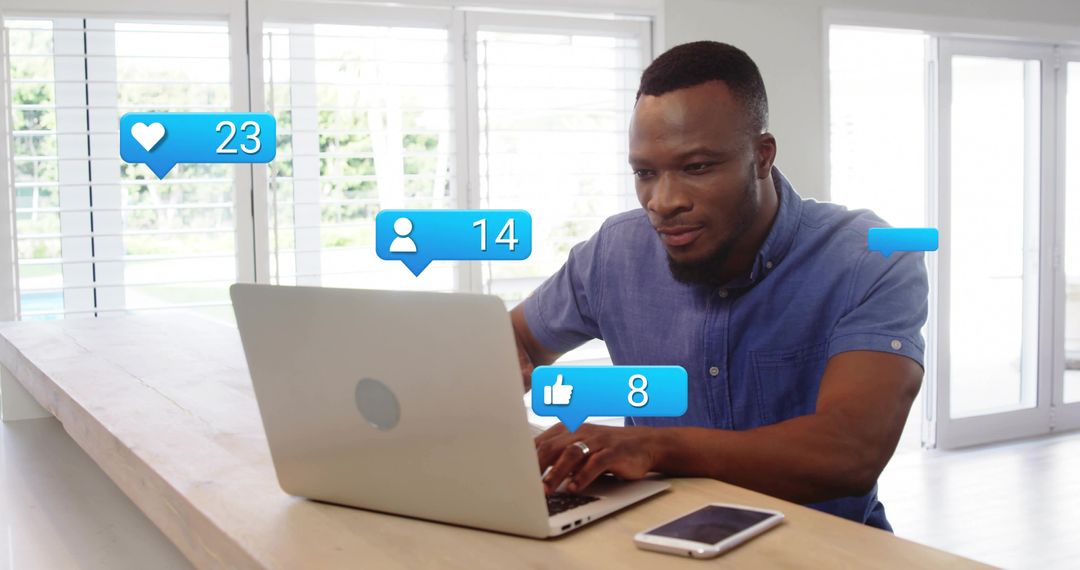 Man Engaged with Social Media while Working on Laptop at Home Kitchen