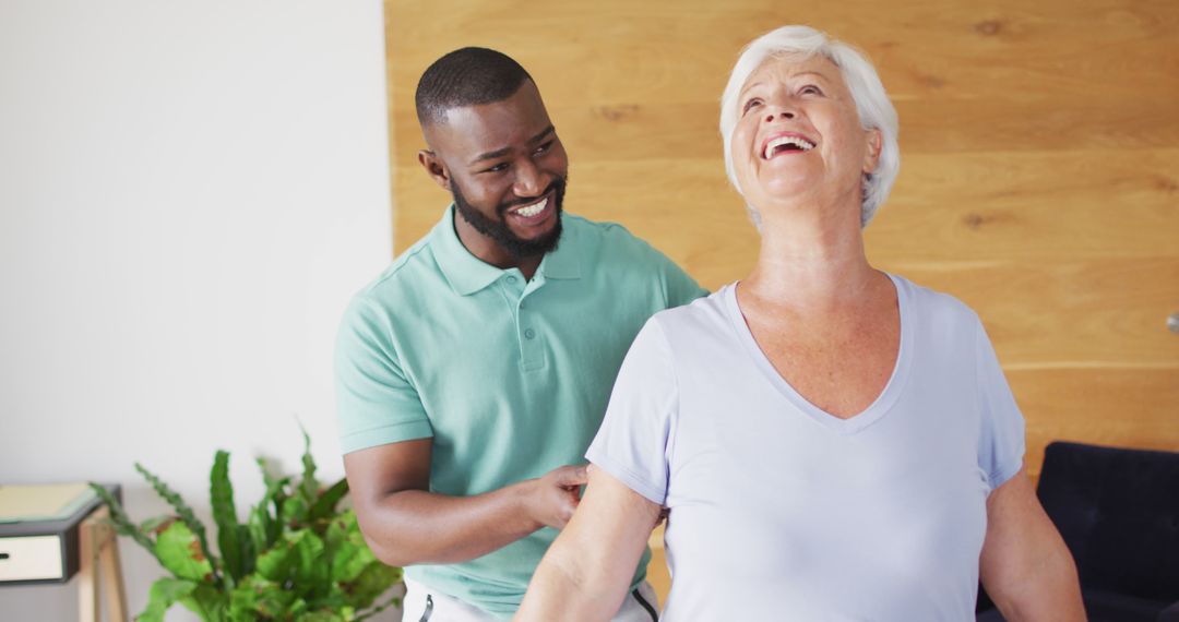 Image of happy african american male physiotherapist examining caucasian senior woman - Free Images, Stock Photos and Pictures on Pikwizard.com