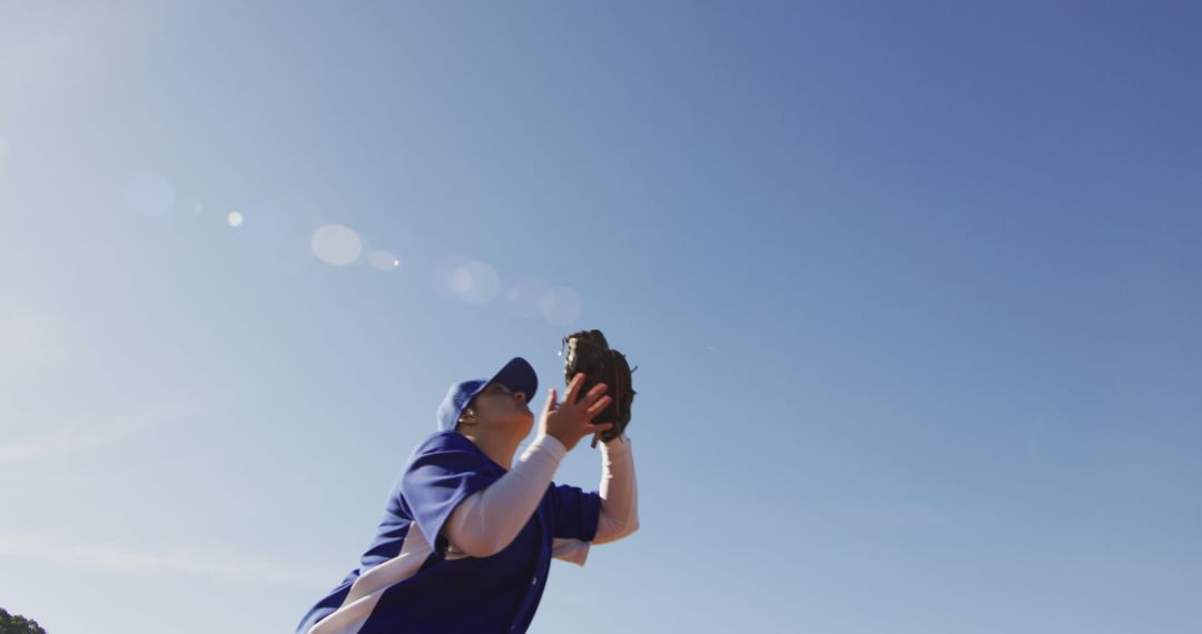 Baseball Player Catching Ball in Bright Blue Sky - Free Images, Stock Photos and Pictures on Pikwizard.com