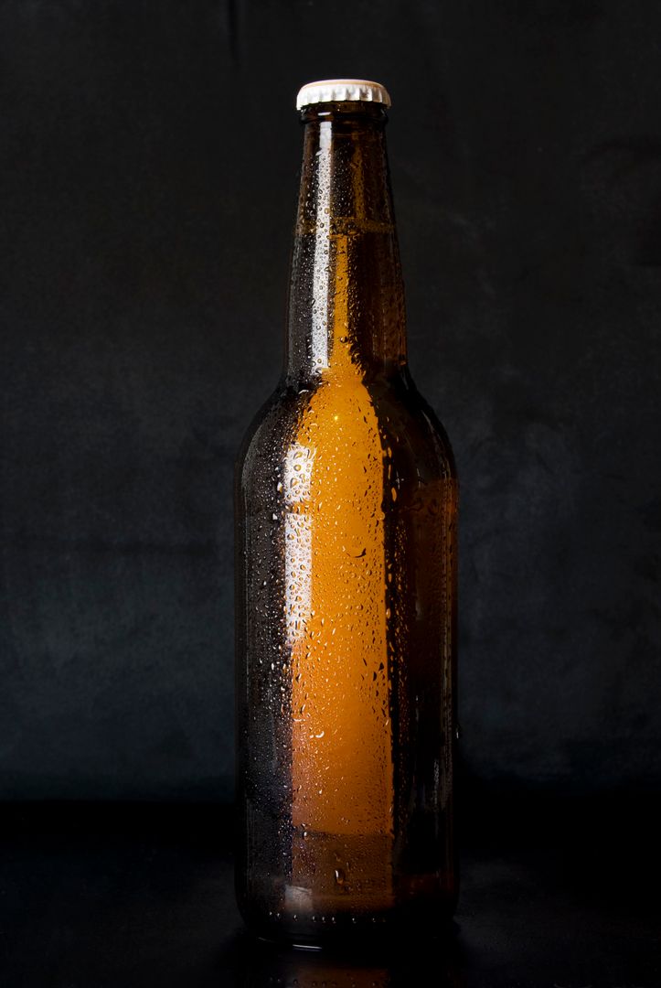 Chilled Brown Glass Beer Bottle with Condensation on Dark Background - Free Images, Stock Photos and Pictures on Pikwizard.com