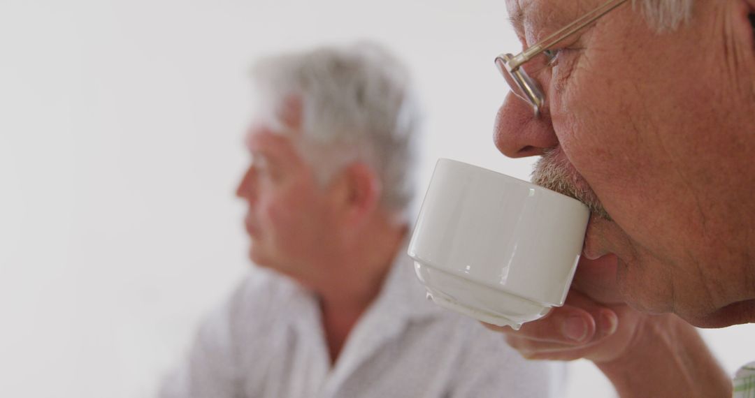 Elderly Man Enjoying Coffee With Friend in Bright Room - Free Images, Stock Photos and Pictures on Pikwizard.com