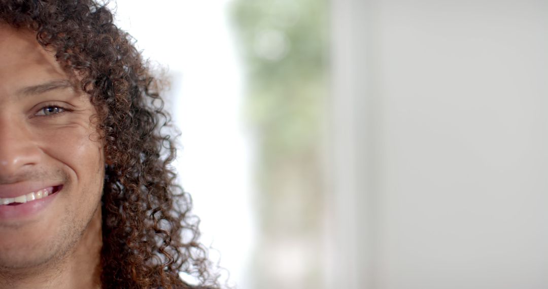 Close-Up of Smiling Curly-Haired Person in Bright Room - Free Images, Stock Photos and Pictures on Pikwizard.com