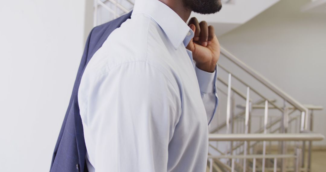 Professional Man Carrying Suit Jacket Over Shoulder in Office - Free Images, Stock Photos and Pictures on Pikwizard.com