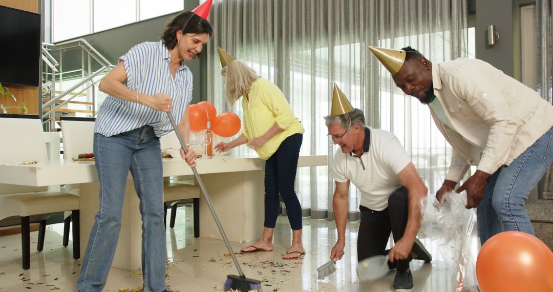 Diverse Team Cleaning Up After Office Celebration in Lounge