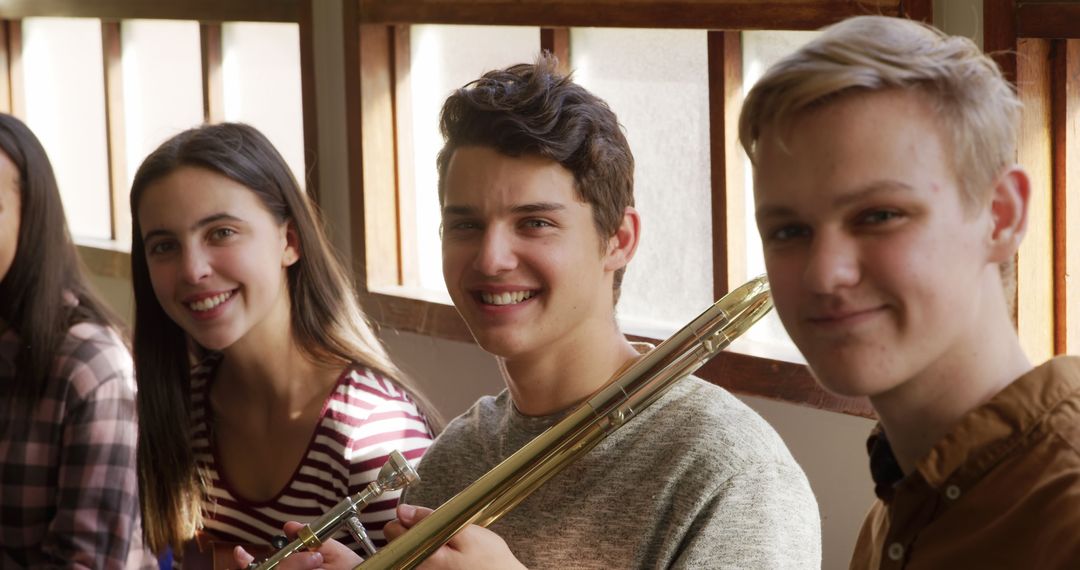 Teenagers Smiling and Playing Musical Instruments Indoors - Free Images, Stock Photos and Pictures on Pikwizard.com