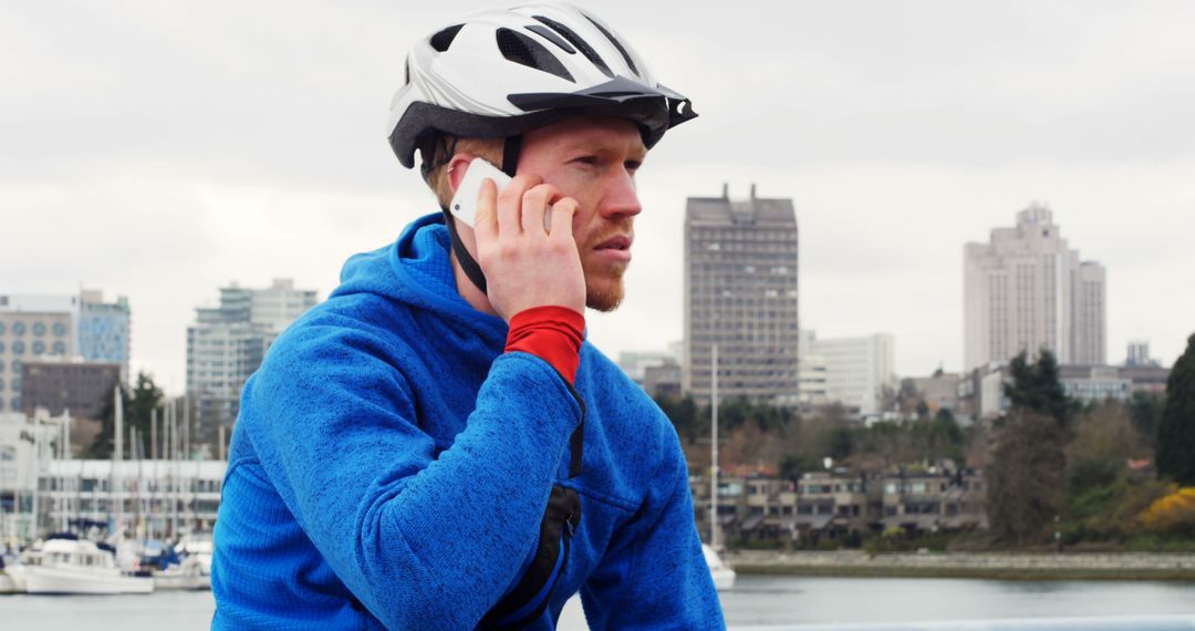 Man in Blue Jacket and Helmet Talking on Smartphone Outdoors - Free Images, Stock Photos and Pictures on Pikwizard.com