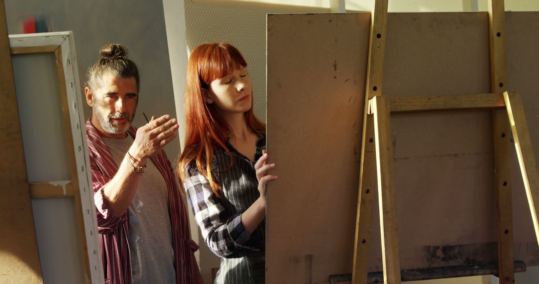 Art Instructor Teaching Young Woman Painting Techniques in Studio - Free Images, Stock Photos and Pictures on Pikwizard.com